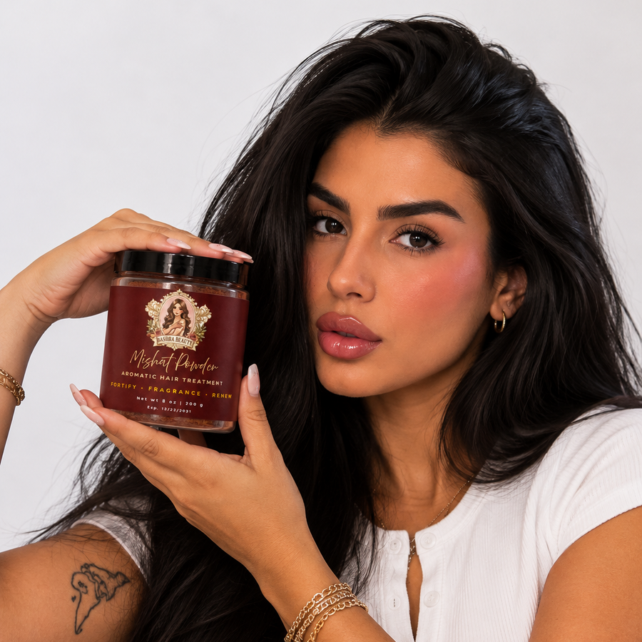 A woman with long dark hair holds up a jar of 'Noble Powder' face powder against a plain light gray background. She is wearing a white top and gold bracelets.