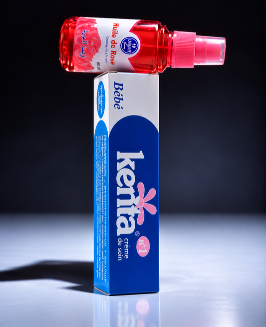 Blue Kenta Bébé cream box displayed alongside a red rose oil spray bottle against a dark background with dramatic studio lighting.