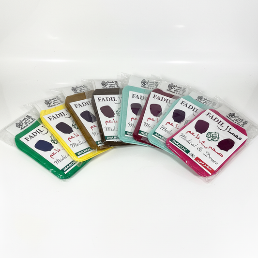 Display of Kessa exfoliating hammam gloves in multiple colors including green, yellow, brown, teal, burgundy, and pink, Medical & Douce grade, made in Morocco