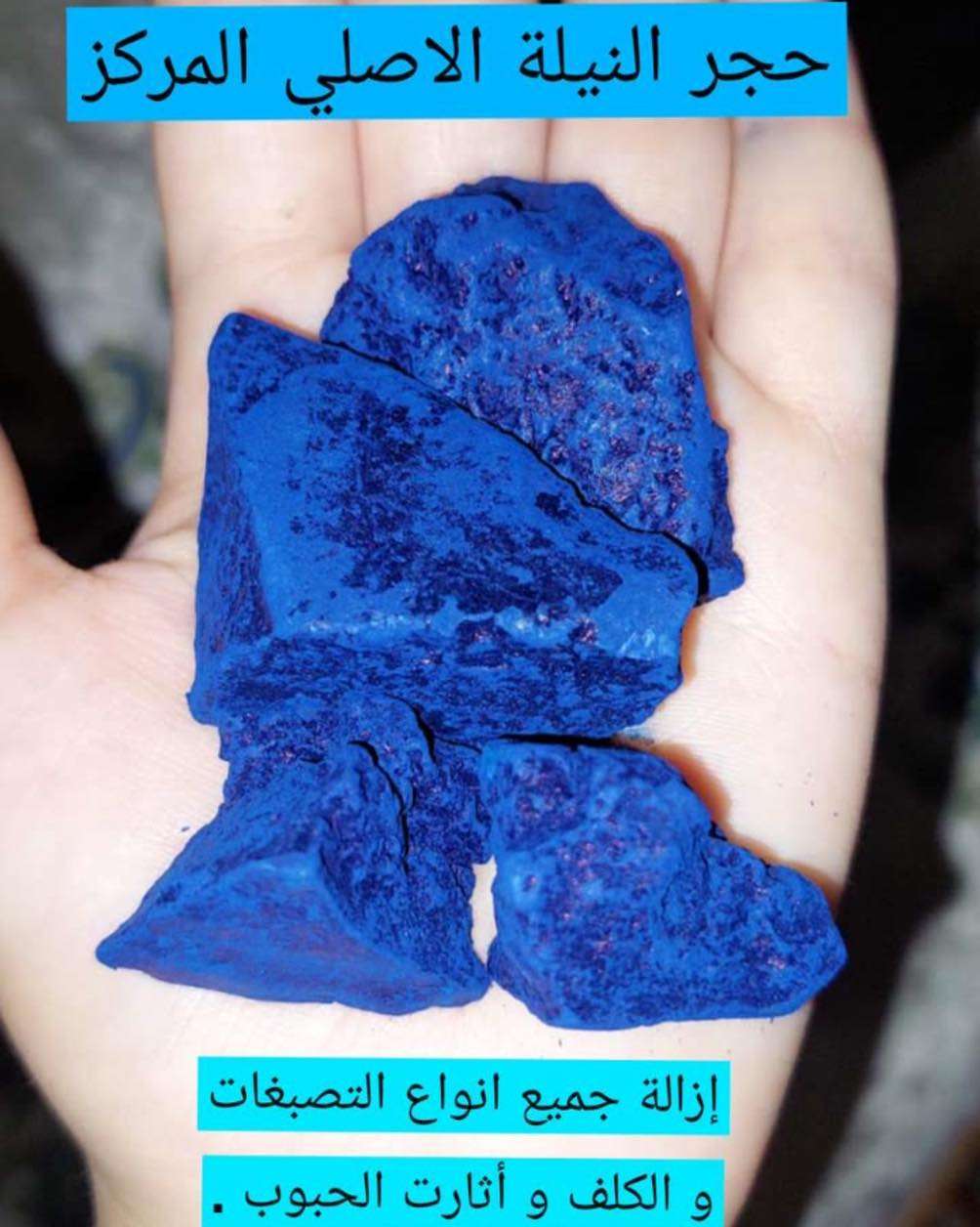 Blue stone held in a hand with Arabic text on a dark background