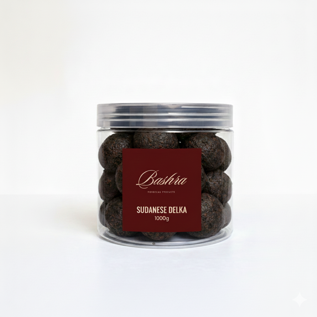 A clear, 1000g plastic jar filled with dark, round balls of Sudanese Delka. 