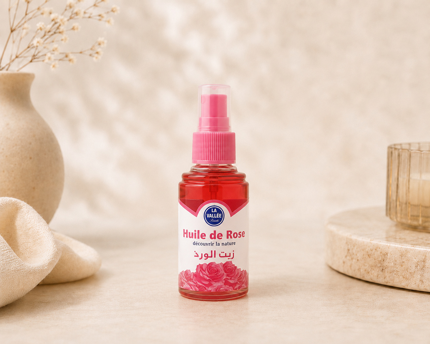 Bashra Beauty Moroccan Rose Oil in a pink glass bottle displayed on a neutral spa-inspired background for radiant, hydrated skin.