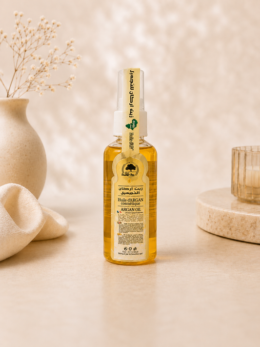 Pure Moroccan Argan Oil displayed in a luxury spa-inspired setting. Cold-pressed argan oil for nourishing skin, hair, nails, and daily hydration