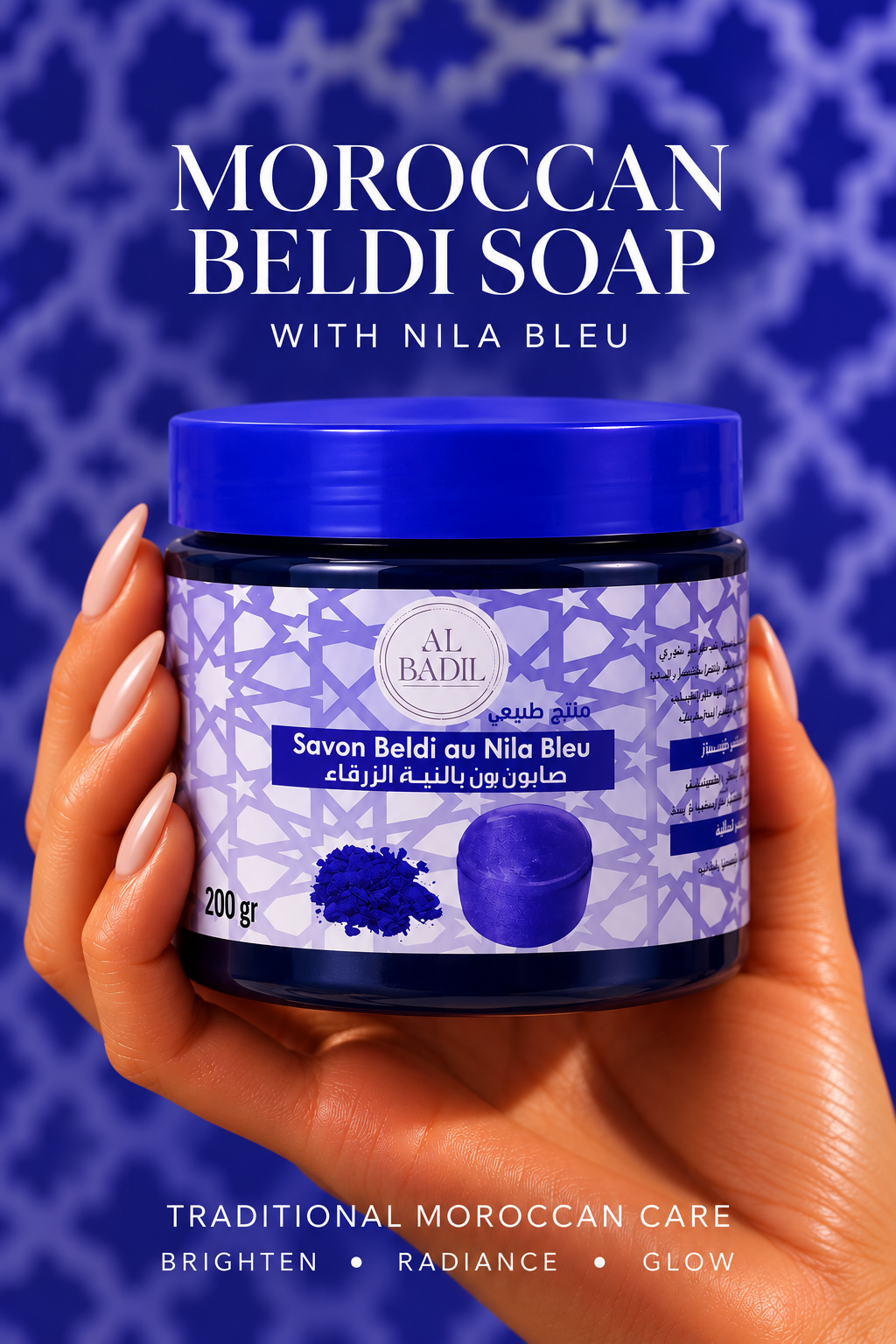 Moroccan beldi soap with Nila Bleu in a blue jar, held in a hand against a deep blue Moroccan geometric background.